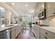 Open kitchen view with stainless appliances, white cabinets, and hardwood floors at 11395 Crestview Ter, Johns Creek, GA 30024