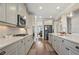 Well-lit kitchen featuring stainless steel appliances, white cabinets, and beautiful hardwood floors at 11395 Crestview Ter, Johns Creek, GA 30024