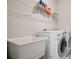 Efficient laundry room features modern washer and dryer, shelving for storage, and utility sink at 11395 Crestview Ter, Johns Creek, GA 30024
