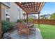 Outdoor patio with wooden pergola, dining set, lush plants, and comfortable seating, perfect for entertaining at 11395 Crestview Ter, Johns Creek, GA 30024