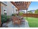 Covered patio with a wooden dining table set and manicured yard at 11395 Crestview Ter, Johns Creek, GA 30024