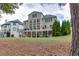 The home has a massive backyard, featuring a large deck, covered patio, manicured landscaping, and mature trees at 1718 Autumn Sage Dr, Dacula, GA 30019