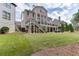 Expansive backyard with a deck, patio, lush lawn, and mature trees, ideal for outdoor activities at 1718 Autumn Sage Dr, Dacula, GA 30019