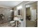 Well-lit bathroom with tile flooring, a pedestal sink, and tiled walk-in shower at 1718 Autumn Sage Dr, Dacula, GA 30019