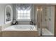 Bright bathroom featuring a soaking tub, separate shower, and neutral tile at 1718 Autumn Sage Dr, Dacula, GA 30019