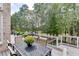 Inviting deck with a dining table and chairs overlooking the serene backyard landscape at 1718 Autumn Sage Dr, Dacula, GA 30019