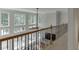 Hallway featuring a view through large windows with a metal and wood railing in the foreground at 1718 Autumn Sage Dr, Dacula, GA 30019