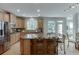 Eat-in kitchen features a breakfast bar island, stainless appliances, and a view to the deck at 1718 Autumn Sage Dr, Dacula, GA 30019