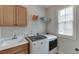 This laundry room features a sink and white washing machines at 1718 Autumn Sage Dr, Dacula, GA 30019
