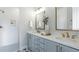 Elegant bathroom with double sinks, modern fixtures, white subway tile shower, and decorative floor tiles at 4210 Provenance Trl, Cumming, GA 30028