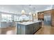 Bright, open kitchen featuring a large island, modern lighting, stainless steel appliances, and wood floors at 4210 Provenance Trl, Cumming, GA 30028