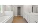 Bright bathroom featuring double vanity, soaking tub, glass shower, and walk-in closet access at 363 Riverwood Pass, Dallas, GA 30157