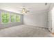 Spacious bedroom with carpet, ceiling fan, and abundant natural light from the three windows at 363 Riverwood Pass, Dallas, GA 30157