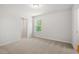 Carpeted bedroom featuring large closet and a bright window with view of mature trees at 363 Riverwood Pass, Dallas, GA 30157