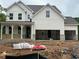 Two-story white home featuring a covered porch and unfinished two-car garage at 363 Riverwood Pass, Dallas, GA 30157