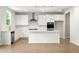 Modern white kitchen featuring stainless steel appliances, stylish pendant lights, and a large island at 363 Riverwood Pass, Dallas, GA 30157
