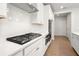 Modern kitchen with stainless steel appliances, a sleek range hood, white herringbone backsplash, and quartz countertops at 363 Riverwood Pass, Dallas, GA 30157