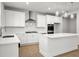 Well-lit kitchen showcasing white cabinets, quartz countertops, stainless steel appliances, and a functional center island at 363 Riverwood Pass, Dallas, GA 30157
