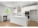 Bright kitchen with white cabinetry, stainless steel appliances, large island, and elegant pendant lighting at 363 Riverwood Pass, Dallas, GA 30157