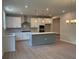 Open kitchen with white cabinetry, stainless steel appliances, and a gray kitchen island at 363 Riverwood Pass, Dallas, GA 30157