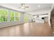 Bright living room with light wood floors, large windows, and a modern kitchen with a center island at 363 Riverwood Pass, Dallas, GA 30157