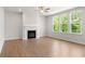 Bright living room with hardwood floors, a cozy fireplace, and large windows showcasing the outdoor view at 363 Riverwood Pass, Dallas, GA 30157