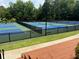 Well-maintained tennis courts with blue and green surfaces, surrounded by trees and fencing at 363 Riverwood Pass, Dallas, GA 30157