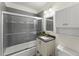 Updated bathroom featuring a shower-tub combination with sliding glass door, grey tiles, and a granite vanity at 385 Jayne Ellen Way, Alpharetta, GA 30009