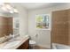Bright bathroom with a granite countertop, a tiled shower-tub combo, and a window bringing in natural light at 385 Jayne Ellen Way, Alpharetta, GA 30009