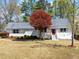 Charming single-story home with a well-manicured lawn and inviting front porch, highlighted by a vibrant red tree at 385 Jayne Ellen Way, Alpharetta, GA 30009