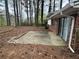 Exterior shot of a concrete back patio with sliding glass doors surrounded by a lush wooded area at 3025 Mckenzie Rd, Atlanta, GA 30344