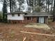 Home featuring a brick and white-sided exterior with a concrete patio in a wooded backyard at 3025 Mckenzie Rd, Atlanta, GA 30344