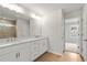 Bright bathroom with double vanity, white cabinets, stone countertop, and tiled shower with glass doors at 373 Riverwood Pass, Dallas, GA 30157