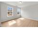 Bedroom with wood-look floors, neutral paint, and two windows overlooking the backyard at 373 Riverwood Pass, Dallas, GA 30157