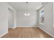 Bright dining room with wood floors, a modern chandelier, and large windows at 373 Riverwood Pass, Dallas, GA 30157