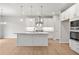 Bright, new kitchen features an island, stainless appliances, white cabinets, and wood floors at 373 Riverwood Pass, Dallas, GA 30157