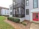 Multi-level condo with screened porch area, manicured landscaping, and red front door at 88 Peachtree Memorial Nw Dr # 88, Atlanta, GA 30309