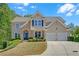 Charming home featuring stone accents, a well-manicured lawn, and an attached two-car garage at 1210 Spring Branch Ct, Lawrenceville, GA 30045