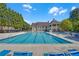 Large swimming pool with ample seating and a clubhouse in the background in a residential community at 1210 Spring Branch Ct, Lawrenceville, GA 30045
