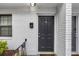 A dark front door of unit 6 in front of a white brick exterior wall at 1683 Briarcliff Rd # 6, Atlanta, GA 30306