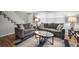 Well-lit living room with gray furniture, hardwood floors, a window, and white stairs at 1683 Briarcliff Rd # 6, Atlanta, GA 30306