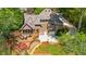 Aerial view of the home, deck, manicured lawn, driveway, and surrounding trees at 2675 Misty Morning Ln, Roswell, GA 30076