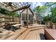 Multi-level deck with a hot tub, screened-in porch, and outdoor dining area, surrounded by lush greenery at 2675 Misty Morning Ln, Roswell, GA 30076