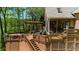 Multi-level backyard deck featuring a hot tub, pergola, dining area, grill and steps leading to the yard at 2675 Misty Morning Ln, Roswell, GA 30076