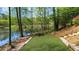 Beautiful backyard with a grassy area, stone retaining wall, steps, and lake views at 2675 Misty Morning Ln, Roswell, GA 30076