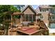 Two-story house featuring a deck with an outdoor dining area and a hot tub with lush landscaping at 2675 Misty Morning Ln, Roswell, GA 30076