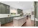 Spacious kitchen with custom green cabinets, marble countertops, and a center island at 2675 Misty Morning Ln, Roswell, GA 30076