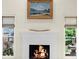 Living room fireplace with painted mantel and surrounding windows with views of the exterior at 2675 Misty Morning Ln, Roswell, GA 30076