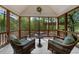 Inviting screened porch with wicker furniture and views of the surrounding trees and a hot tub in the distance at 2675 Misty Morning Ln, Roswell, GA 30076