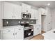 A kitchen features white cabinets, stainless steel appliances, and a gray subway tile backsplash at 27 Kensington St, Kingston, GA 30145